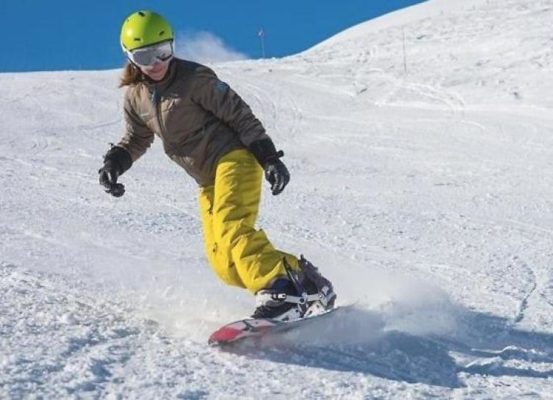 op deze afbeelding staat een skiër met een gele skibroek en een Oakley skibril.
